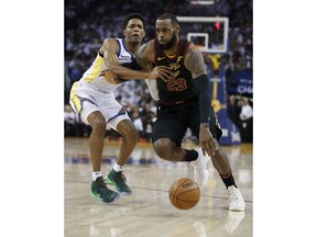 Cleveland Cavaliers forward LeBron James (23) drives to the basket past Golden State Warriors guard Patrick McCaw during the first half of an NBA basketball game in Oakland, Calif., Monday, Dec. 25, 2017.