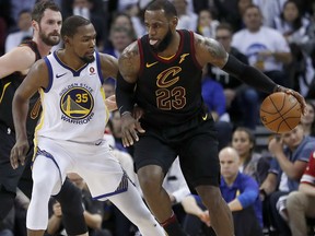 Cleveland Cavaliers forward LeBron James (23) moves the ball around Golden State Warriors forward Kevin Durant (35) during the second half of an NBA basketball game in Oakland, Calif., Monday, Dec. 25, 2017. The Warriors won 99-92.