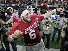 Oklahoma quarterback Baker Mayfield celebrates as he puts on his championship t-shirt after their Big 12 Conference championship NCAA college football game against TCU on Saturday, Dec. 2, 2017, in Arlington, Texas.