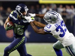Seattle Seahawks wide receiver Tyler Lockett (16) carries the ball as his face masked is grabbed by Dallas Cowboys cornerback Chidobe Awuzie (33) in the second half of an NFL football game, Sunday, Dec. 24, 2017, in Arlington, Texas.