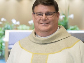 In this Dec. 19, 2017 photo provided by St. Bernadette Parish Rev. Gregory Greiten poses for a photo at the Parish in Milwaukee. The Roman Catholic priest was greeted with a standing ovation from parishioners when he told them of his sexual orientation. The Milwaukee Journal Sentinel reports that Rev. Greiten came out as gay to the St. Bernadette Parish on Sunday, Dec. 17. He then came out in a column in the National Catholic Reporter on Monday. Greiten says he revealed his sexual orientation because he wants to be a role model for others. (St. Bernadette Parish via AP)