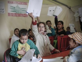 In this Dec. 1, 2014 photo provided by Sam Tarling and The John D. and Catherine T. MacArthur Foundation, young refugees from Syria appear in an education center run by the International Rescue Committee at an informal tented settlement for Syrian refugees near the town of Bkaida, Lebanon. The John D. and Catherine T. MacArthur Foundation announced Wednesday, Dec. 20, 2017, that Sesame Workshop and the International Rescue Committee will get a $100 million grant from a Chicago-based foundation. for a joint program that will include home visits focused on early learning, child development centers and a local version of "Sesame Street."