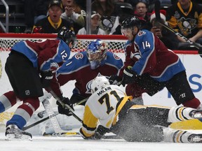 Pittsburgh Penguins center Evgeni Malkin, front, of Russia, tumbles to the ice as his shot is stopped by Colorado Avalanche goalie Semyon Varlamov, of Russia, back center, as defenseman Patrik Nemeth, left, of Sweden, and left wing Blake Comeau defend in the first period of an NHL hockey game, Monday, Dec. 18, 2017, in Denver.
