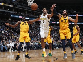 Denver Nuggets forward Trey Lyles, center, battles for control of a rebound with Utah Jazz center Ekpe Udoh, left, and guard Ricky Rubio, of Spain, in the first half of an NBA basketball game, Tuesday, Dec. 26, 2017, in Denver.