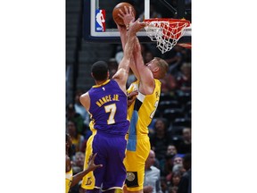 Los Angeles Lakers forward Larry Nance Jr., left, is called for a foul as Denver Nuggets center Mason Plumlee goes up for a basket in the first half of an NBA basketball game Saturday, Dec. 2, 2017, in Denver.