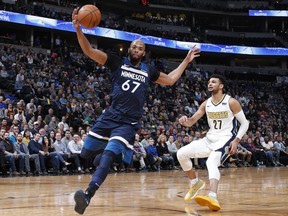 Minnesota Timberwolves forward Taj Gibson, front, pulls in a loose ball in front of Denver Nuggets guard Jamal Murray in the first half of an NBA basketball game Wednesday, Dec. 20, 2017, in Denver.