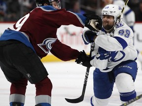 Colorado Avalanche defenseman Samuel Girard, left, hits Tampa Bay Lightning center Cory Conacher on the face as he drives to the net in the second period of an NHL hockey game Saturday, Dec. 16, 2017, in Denver.