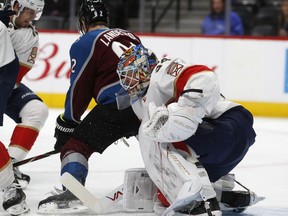 Florida Panthers goalie James Reimer, front, stops the puck as Colorado Avalanche left wing Gabriel Landeskog, of Sweden, falls into the goalie in the first period of an NHL hockey game Thursday, Dec. 14, 2017, in Denver.