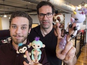 Wowee creative director Benny Dongarra, right, and mechanical engineer Anthony Lemire hold Fingerlings in Montreal, Thursday, December 7, 2017l.