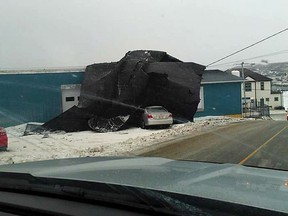 Part of a hardware store's roof is shown against the side of a building in this photo provide by Terry Osmond after high winds in Port-aux-Basque, Newfoundland on Monday Dec. 25, 2017. Gusts reached up to 120 kilometres per hour in the community in recent days, and the ferries between Channel-Port aux Basques, N.L., and North Sydney, N.S. cancelled service due to rough weather in the Cabot Strait.