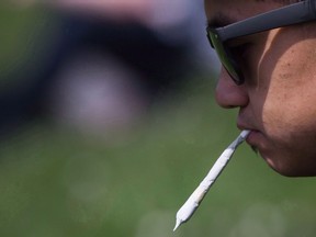 A man holds a joint between his lips during the annual 4-20 cannabis culture celebration at Sunset Beach in Vancouver on April 20, 2017.