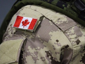 A Canadian flag patch is shown on a soldier's shoulder in Trenton, Ont., on Thursday, Oct. 16, 2014. A group of injured veterans have suffered a major setback in their landmark legal battle with the federal government.