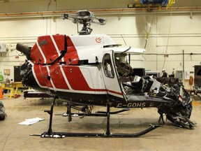 The wreckage of a helicopter is shown at the Transportation Safety Board of Canada's lab in Ottawa in this recent handout photo. The Transportation Safety Board says evidence suggests a tool bag being carried outside a Hydro One helicopter struck the rear rotor of the aircraft just prior to a crash in eastern Ontario that killed all four people aboard.