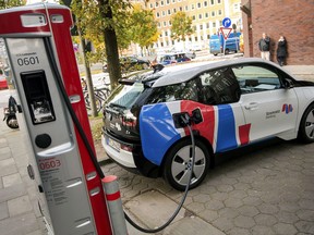 FILE - In this Wednesday, Oct. 18, 2017 photo a car is connected to a charging station for electric vehicles in Hamburg, Germany. A Canadian energy think tank says the world is less than a decade away from the tipping point at which electric cars will cost the same as conventional gas-powered vehicles. THE CANADIAN PRESS/Daniel Bockwoldt/dpa via AP, File)