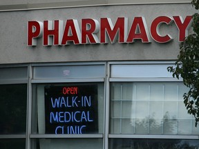 A sign for a pharmacy and walk-in health clinic shown in Oakville, Ont., Thursday, Oct.13, 2016. The federal government says it is proposing changes to patented medicine regulations aimed at dropping drug prices, representing the first major update in more than two decades. THE CANADIAN PRESS IMAGES/Richard Buchan