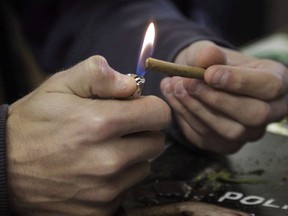 A man lights a marijuana cigarette in Denver on Tuesday, April 25, 2017.