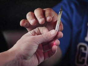 Men pass a marijuana joint as they ride in a tour bus on Wednesday, April 26, 2017 throughout Denver. Governments at both the provincial and federal levels are ramping up their preparations ahead of the legalization of cannabis set for next year. As provinces roll out details for the how, the where and the who-may-buy, the federal government is wrestling with how to deal with dramatic changes required in policing, retailing and in the way society views the long-illegal substance.