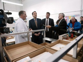 A tentative plea agreement has been reached that would see a Winnipeg-based online pharmacy and two affiliated businesses fined millions of dollars for selling misbranded and counterfeit drugs in the United States. CanadaDrugs.com Director of Pharmacy Robert Fraser, left, takes then-Governor of Minnesota Tim Pawlenty, second from left, on a tour of the internet pharmacy, in Winnipeg on Wednesday, Nov. 12, 2003.