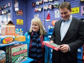 Conservative Leader Andrew Scheer, right, picks up a chocolate version of the Monopoly board game during a visit to a candy store while campaigning with South Surrey-White Rock Conservative by-election candidate Kerry-Lynne Findlay, left, in Surrey, B.C., on Monday December 4, 2017. The Conservative leader and byelection candidate weren't shopping just to soothe a sugar craving. They were making a political point about small business taxes, an issue they're pushing to be front and centre in South Surrey-White Rock.