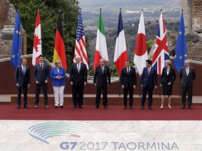 In this May 26, 2017, photo, leaders of the G7, from left, European Council President Donald Tusk, Canadian Prime Minister Justin Trudeau, German Chancellor Angela Merkel, U.S. President Donald J. Trump, Italian Prime Minister Paolo Gentiloni, French President Emmanuel Macron, Japan's Prime Minister Shinzo Abe, British Prime Minister Theresa May and European Commission President Jean-Claude Juncker pose during a group photo for the G7 summit in the Ancient Theatre of Taormina ( 3rd century BC) in the Sicilian citadel of Taormina, Italy.
