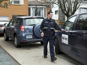 A Canada Border Services Agency officer leaves a residence during an investigation in Dartmouth, N.S. on Wednesday April 10, 2013. The case of a businessman charged with not paying Filipino temporary workers their required wages is expected to be back in Nova Scotia Supreme Court on Tuesday.