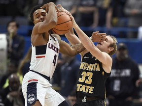 Wichita State's Conner Frankamp, right, pressures Connecticut's Jalen Adams during the first half of an NCAA college basketball game, Saturday, Dec. 30, 2017, in Hartford, Conn.