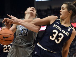 Notre Dame's Kathryn Westbeld, right, knocks the ball away from Connecticut's Katie Lou Samuelson during the first half an NCAA college basketball game, Sunday, Dec. 3, 2017, in Hartford, Conn.