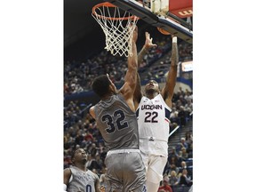 Connecticut's Terry Larrier shoots over Monmouth's Diago Quinn in the first half of an NCAA college basketball game Saturday, Dec. 2, 2017, at the XL Center in Hartford, Conn.