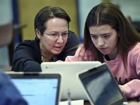 In this, Dec. 20, 2017 photo, Jennifer Rocca, left, a teacher librarian at Brookfield, Conn., High School, left, works with Ariana Mamudi, 14, a freshman in her Digital Student class. The required class teaches media literacy skills and has the students scrutinize sources for their on-line information.