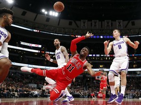 Chicago Bulls guard David Nwaba (11) falls to the floor as he shoots while Sacramento Kings players Frank Mason III (10), Willie Cauley-Stein (00) and Bogdan Bogdanovic (8) watch during the first half of an NBA basketball game in Chicago, Friday, Dec. 1, 2017.
