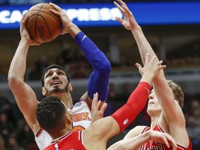 New York Knicks center Enes Kanter (00) shoots against Chicago Bulls forward Denzel Valentine (45) and forward Lauri Markkanen (24) during the first half of an NBA basketball game, Saturday, Dec. 9, 2017, in Chicago.