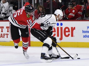 Los Angeles Kings right wing Marian Gaborik (12) and Chicago Blackhawks center Artem Anisimov (15) vie for the puck during the first period of an NHL hockey game Sunday Dec. 3, 2017, in Chicago.