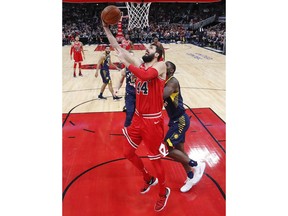 Chicago Bulls forward Nikola Mirotic, center, goes to the basket against Indiana Pacers forward Alex Poythress, right, during the first half of an NBA basketball game, Friday, Dec. 29, 2017, in Chicago.