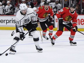 Los Angeles Kings center Nick Shore (21) shoots near Chicago Blackhawks right wing Patrick Kane (88) during the first period of an NHL hockey game Sunday Dec. 3, 2017, in Chicago.