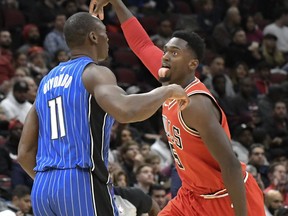 Chicago Bulls forward Bobby Portis (5) reacts after making a three-point basket as he runs past Orlando Magic center Bismack Biyombo (11) during the first half of an NBA basketball game, Wednesday, Dec. 20, 2017, in Chicago.