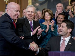 Speaker of the House Paul Ryan, R-Wis., right, shakes hands after presenting a pen to House Ways and Means Committee Chairman Kevin Brady, R-Texas, left, as Senate Majority Leader Mitch McConnell, R-Ky., second from left, watches after signing the final version of the GOP tax bill during an enrollment ceremony at the Capitol in Washington, Thursday, Dec. 21, 2017.