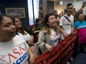 Protesters take over the waiting room of the offices of Senate Minority Leader Sen. Chuck Schumer, D-N.Y., to demand that the Senate pass a clean DREAM Act, on Capitol Hill, Tuesday, Dec. 19, 2017, in Washington.