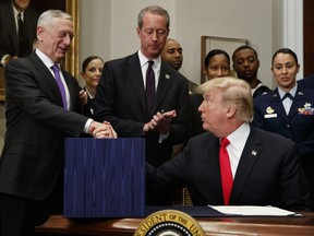 President Donald Trump shakes hands with Secretary of Defense Jim Mattis after signing the National Defense Authorization Act for Fiscal Year 2018, in the Roosevelt Room of the White House, Tuesday, Dec. 12, 2017, in Washington.