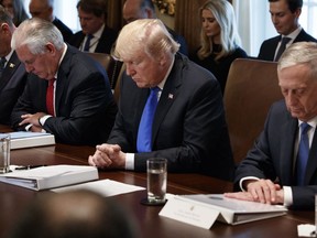 President Donald Trump prays during a cabinet meeting at the White House, Wednesday, Dec. 20, 2017, in Washington. From left, Secretary of Interior Ryan Zinke, Secretary of State Rex Tillerson, Trump, and Secretary of Defense Jim Mattis.