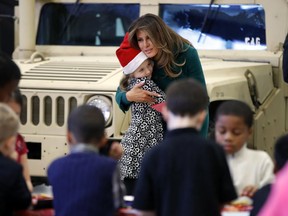 First lady Melania Trump hugs the child of a military family, Wednesday, Dec. 13, 2017, during a "Toys for Tots" event at Joint Base Anacostia-Bolling in Washington.