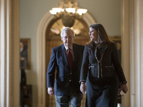 Senate Majority Leader Mitch McConnell, R-Ky., accompanied at right by Secretary for the Majority Laura Dove, walks to his office from the chamber as Republicans in the House and Senate plan to pass the sweeping $1.5 trillion GOP tax bill on party-line votes, at the Capitol in Washington, Monday, Dec. 18, 2017.