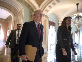 Senate Majority Leader Mitch McConnell, R-Ky., accompanied at right by Secretary for the Majority Laura Dove, walks to the chamber as Republicans in the House and Senate plan to pass the sweeping $1.5 trillion GOP tax bill on party-line votes, at the Capitol in Washington, Monday, Dec. 18, 2017.