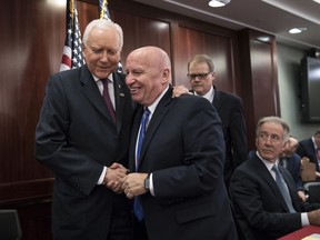 House Ways and Means Committee Chairman Kevin Brady, R-Texas, center, embraces Senate Finance Committee Chairman Orrin Hatch, R-Utah, left, as House and Senate conferees after GOP leaders announced they have forged an agreement on a sweeping overhaul of the nation's tax laws, on Capitol Hill in Washington, Wednesday, Dec. 13, 2017. Rep. Richard Neal, D-Mass., ranking member of the House Ways and Means Committee, looks on at far right. Democrats objected to the bill and asked that a final vote be delayed until Senator-elect Doug Jones of Alabama is seated.