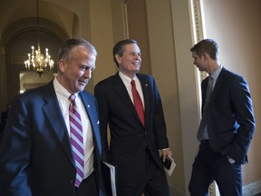 Sen. Dan Sullivan, R-Alaska, left, walks with Sen. Steve Daines, R-Mont., as they head to the Senate chamber after a closed-door meeting with Republican lawmakers to advance the GOP overhaul of the tax code, on Capitol Hill in Washington, Friday, Dec. 1, 2017.