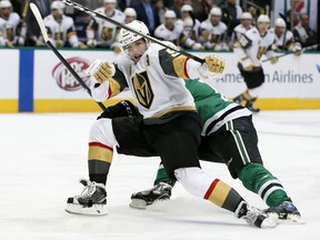 Vegas Golden Knights left wing David Perron (57) loses control of the puck after being hit by Dallas Stars' Radek Faksa during the first period of an NHL hockey game, Saturday, Dec. 9, 2017, in Dallas.