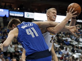 Dallas Mavericks forward Dirk Nowitzki (41) of Germany fouls Denver Nuggets center Mason Plumlee, right, as Plumlee tries to make a pass in the first half of an NBA basketball game, Monday, Dec. 4, 2017, in Dallas.