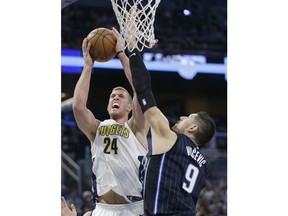 Denver Nuggets' Mason Plumlee (24) goes up against Orlando Magic's Nikola Vucevic (9) for a shot during the first half of an NBA basketball game, Friday, Dec. 8, 2017, in Orlando, Fla.