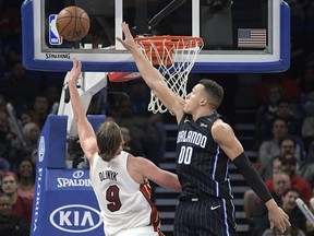 Miami Heat center Kelly Olynyk (9) goes up for a shot in front of Orlando Magic forward Aaron Gordon (00) during the first half of an NBA basketball game Saturday, Dec. 30, 2017, in Orlando, Fla.
