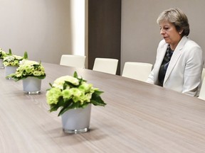 FILE - In this Friday, Oct. 20, 2017 file photo British Prime Minister Theresa May waits for the arrival of European Council President Donald Tusk prior to a bilateral meeting with European Council President Donald Tusk during an EU summit in Brussels. European Union leaders gathered Friday to weigh progress in negotiations on Britain's departure from their club as they look for new ways to speed up the painfully slow moving process.