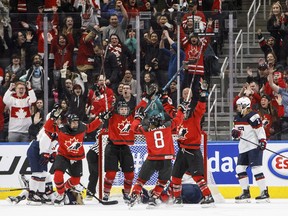 Team Canada celebrates the game-winning overtime goal against the United States in Edmonton on Dec. 17.